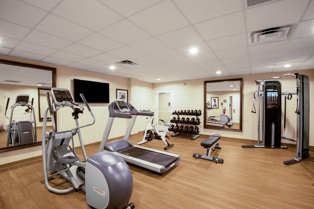 image 24-hour fitness centre with treadmills, elliptical, multi-station weights, and a full dumbbell rack