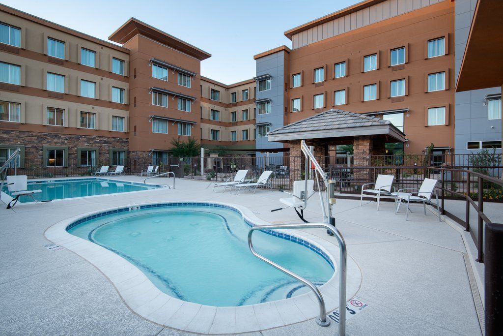 image Outdoor pool with an attached hot tub, shaded gazebo, and white lounge chairs