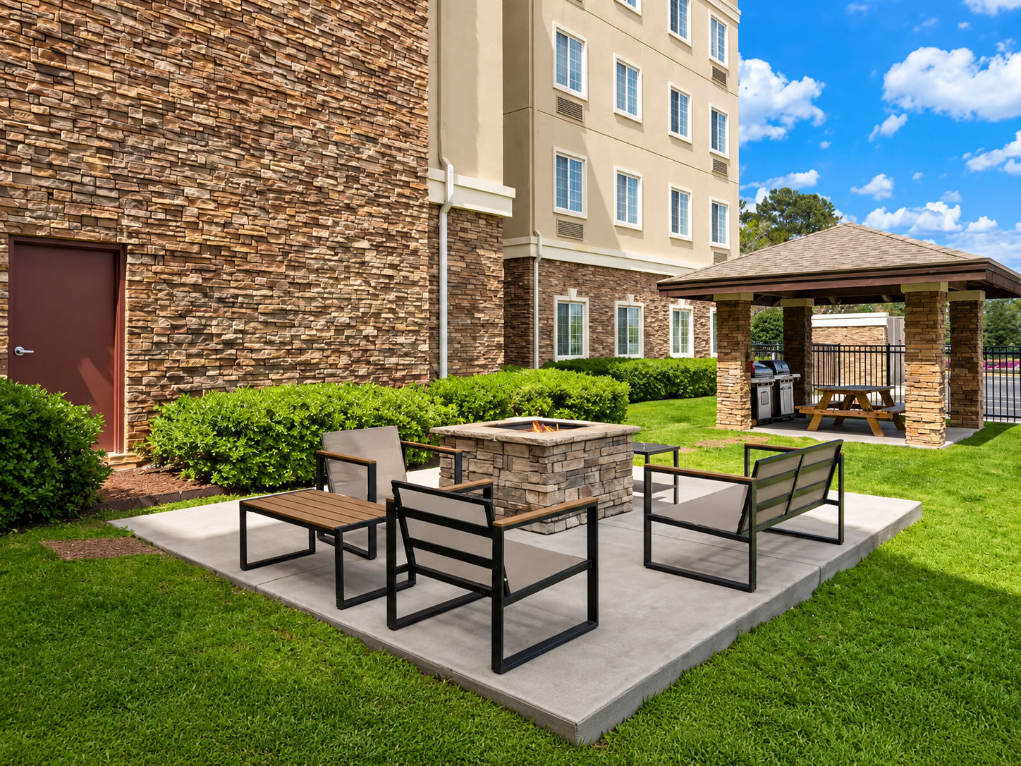 image Outdoor seating area with fire pit and barbecue grill.