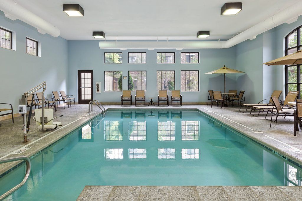 image Unwind by the indoor pool, surrounded by comfortable seating and natural light.