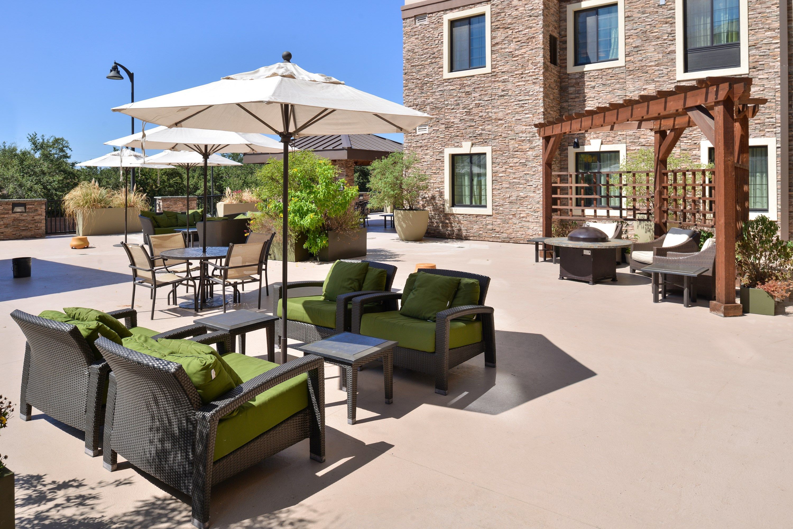 image Outdoor common area with shaded seating and umbrellas.
