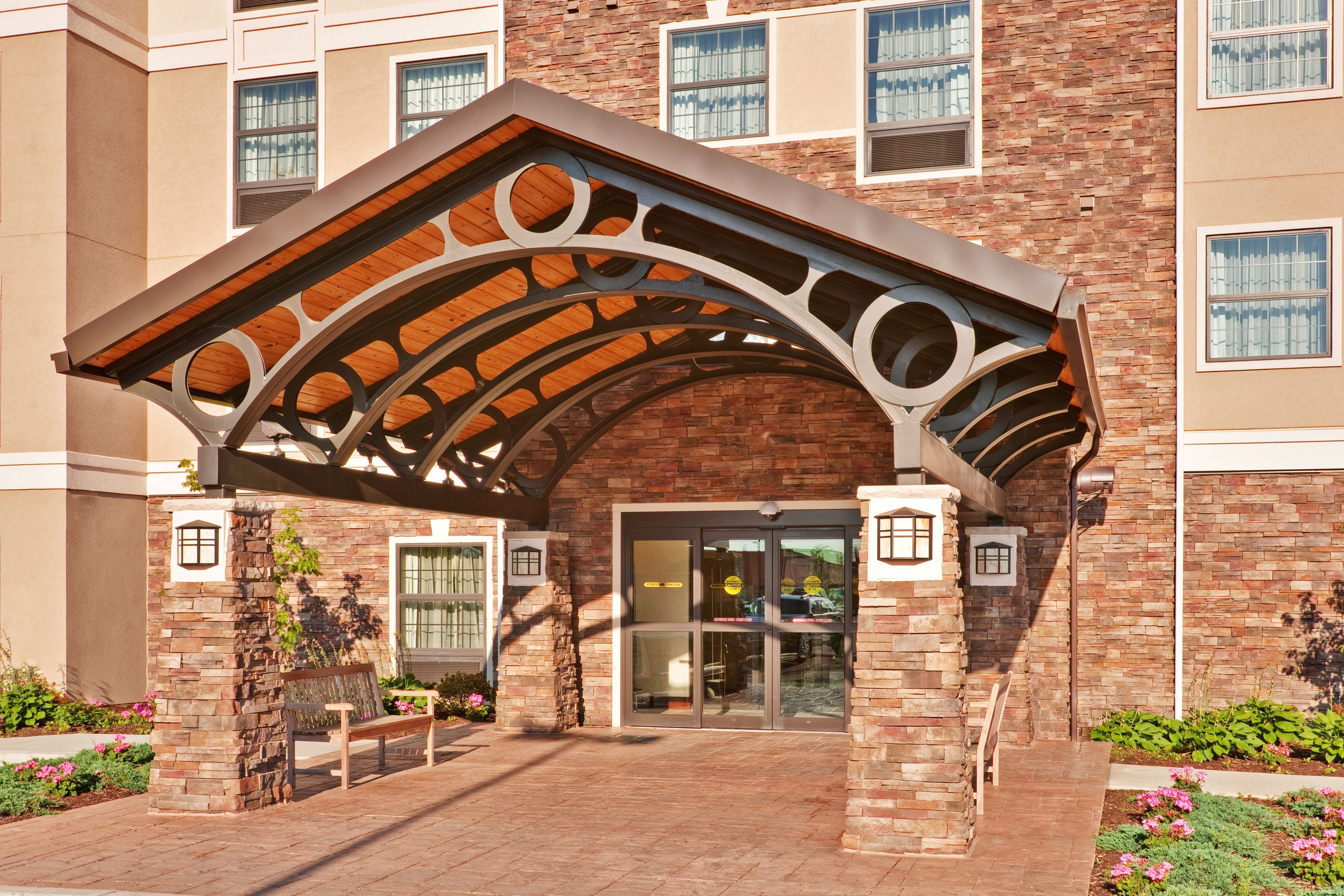 image Elegant entrance canopy with stone pillars and seating area.