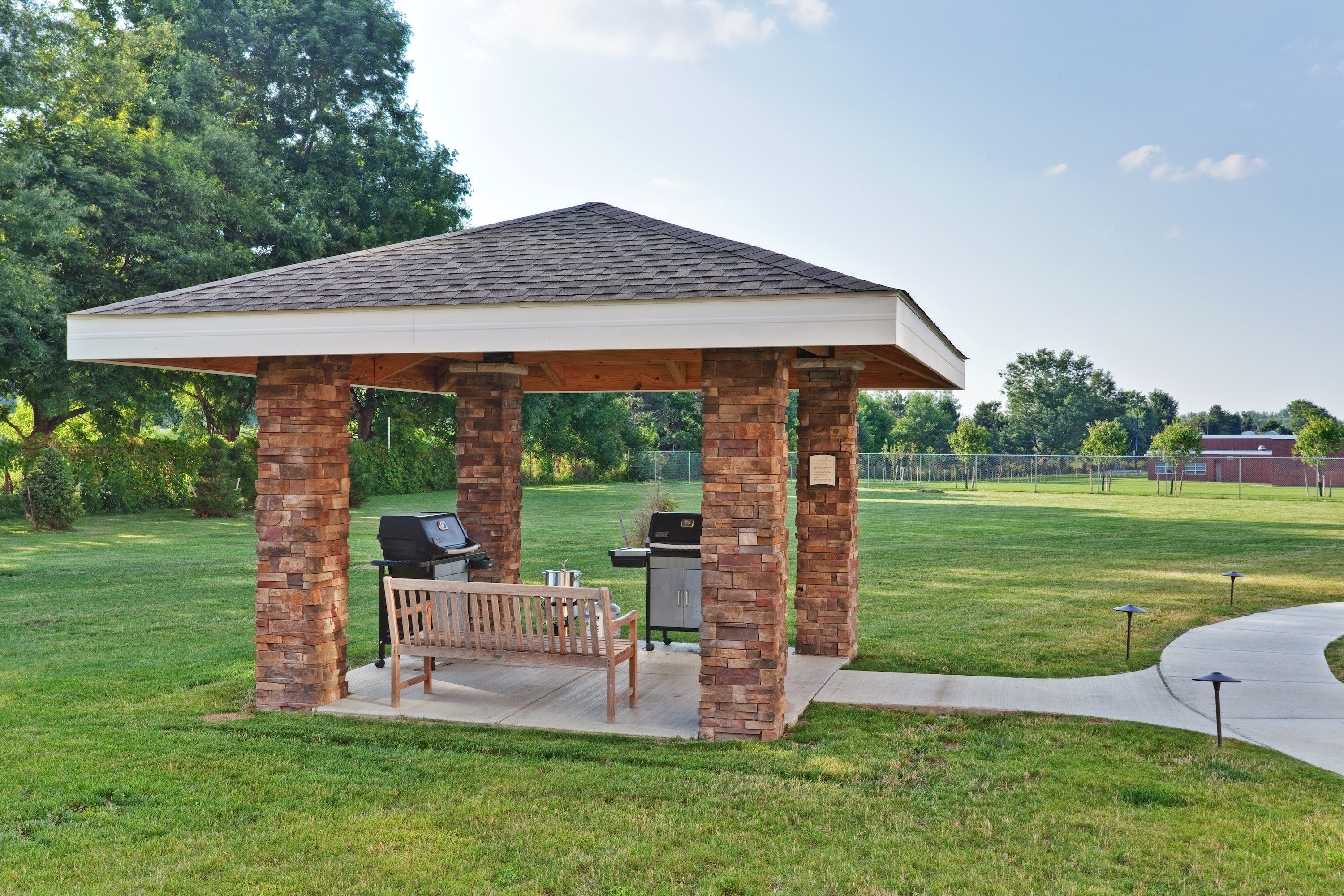 image Outdoor grilling pavilion with BBQ and covered seating.