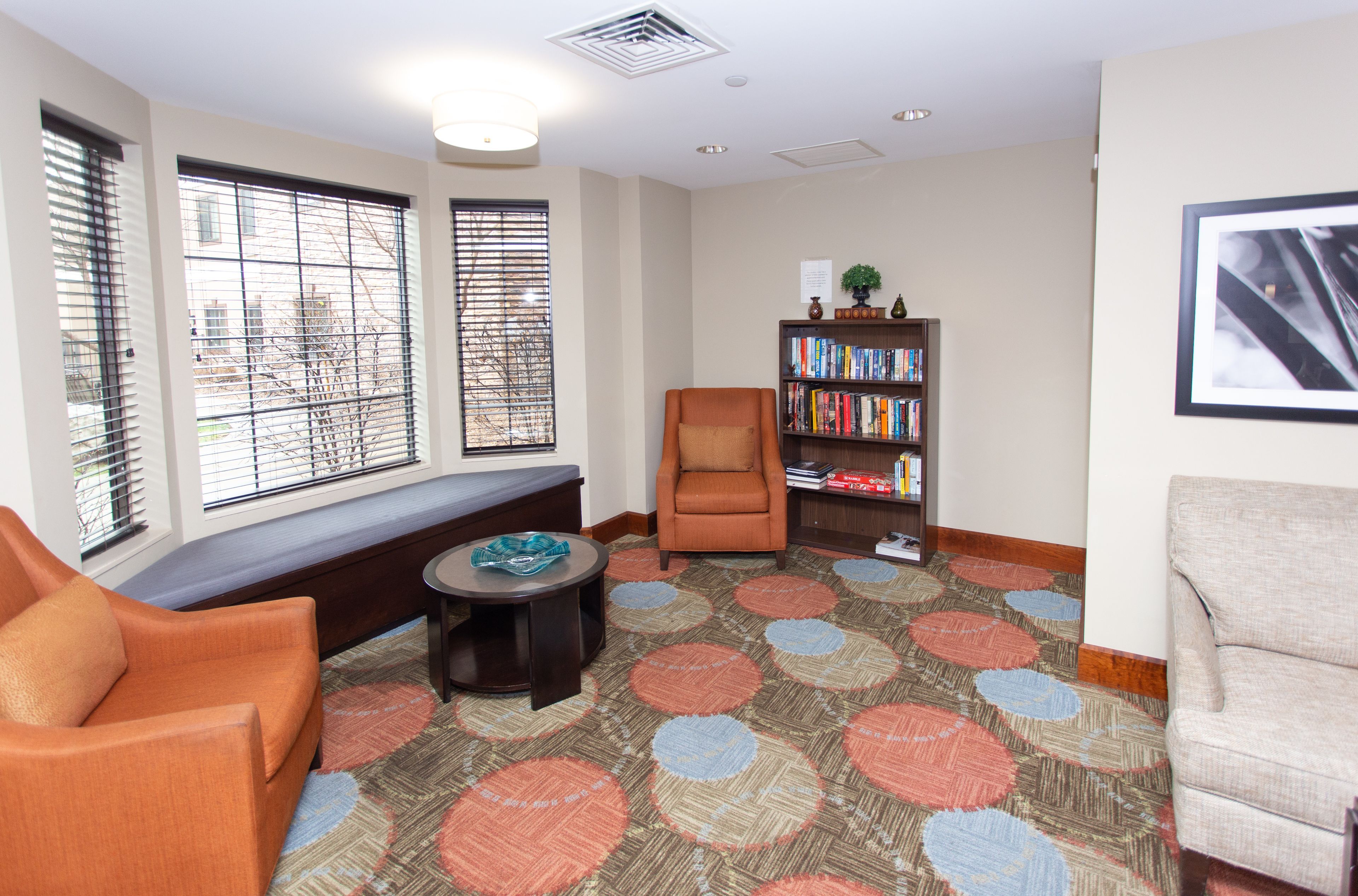 image Cozy reading nook featuring comfortable chairs and a bookshelf.