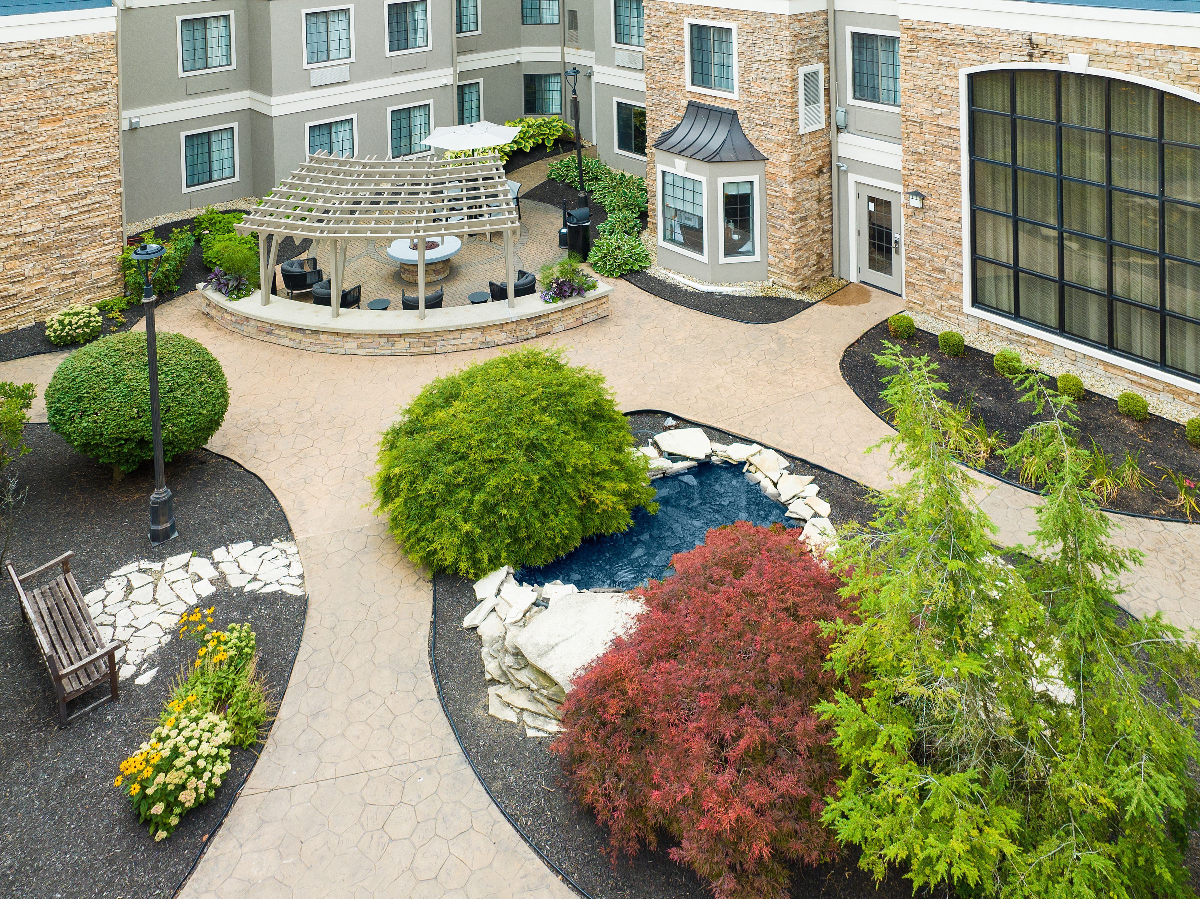 image Outdoor courtyard seating area with potted plants.