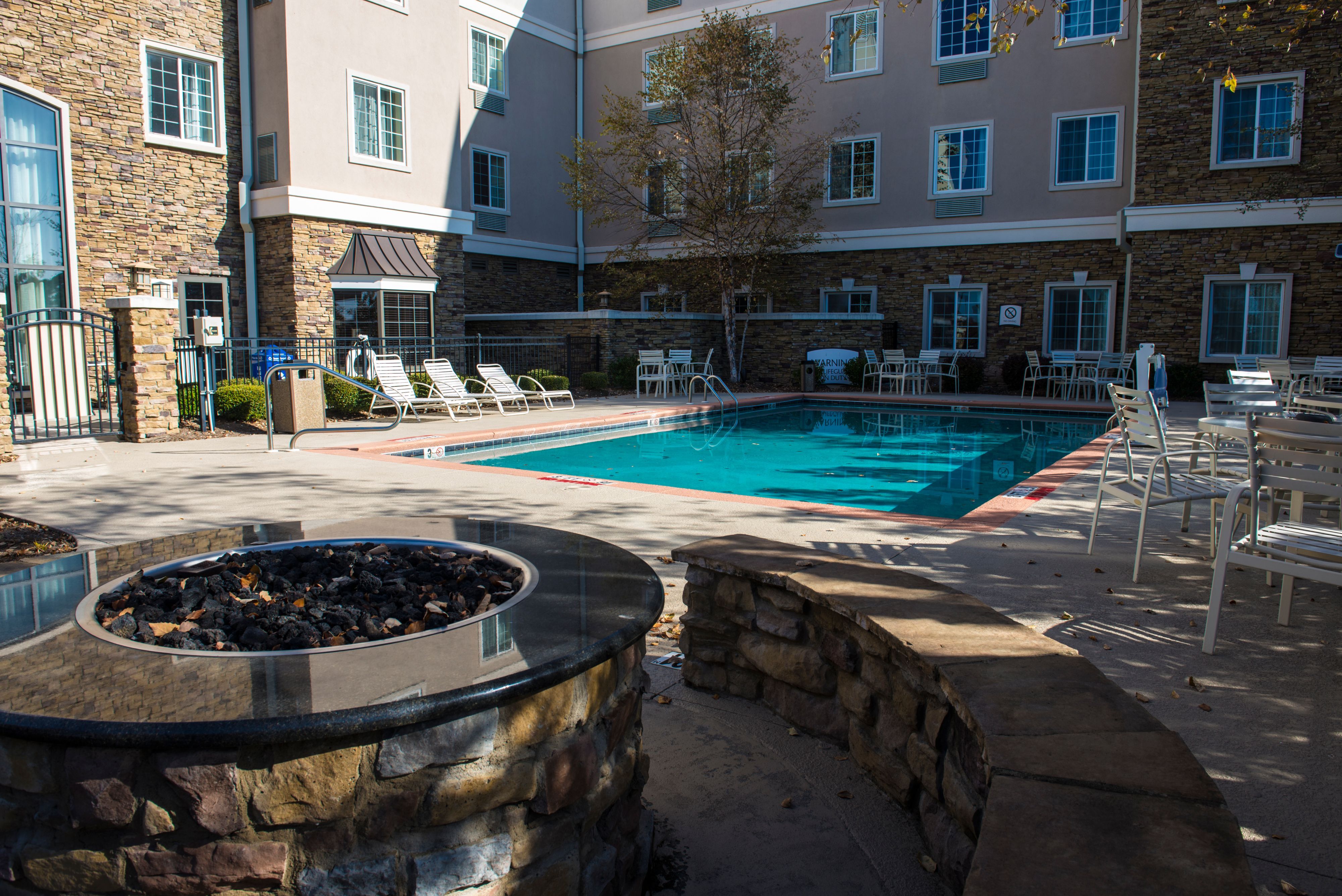image Gather around the outdoor stone fire pit, perfect for cozy evenings by the pool.