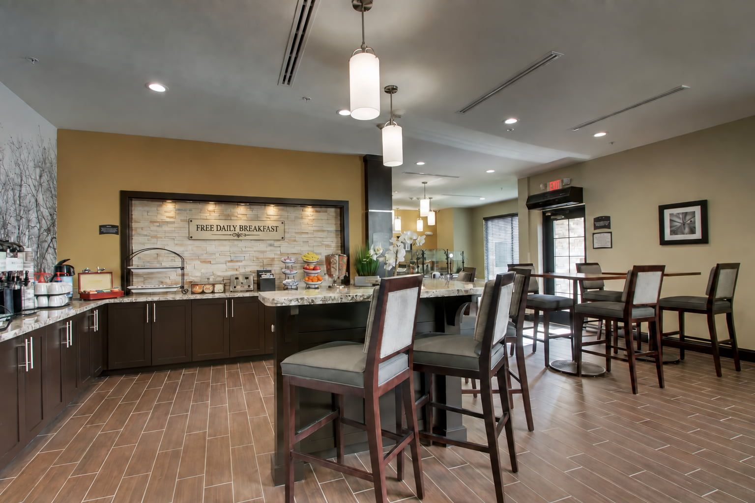 image Breakfast area with seating, food, and beverage stations.