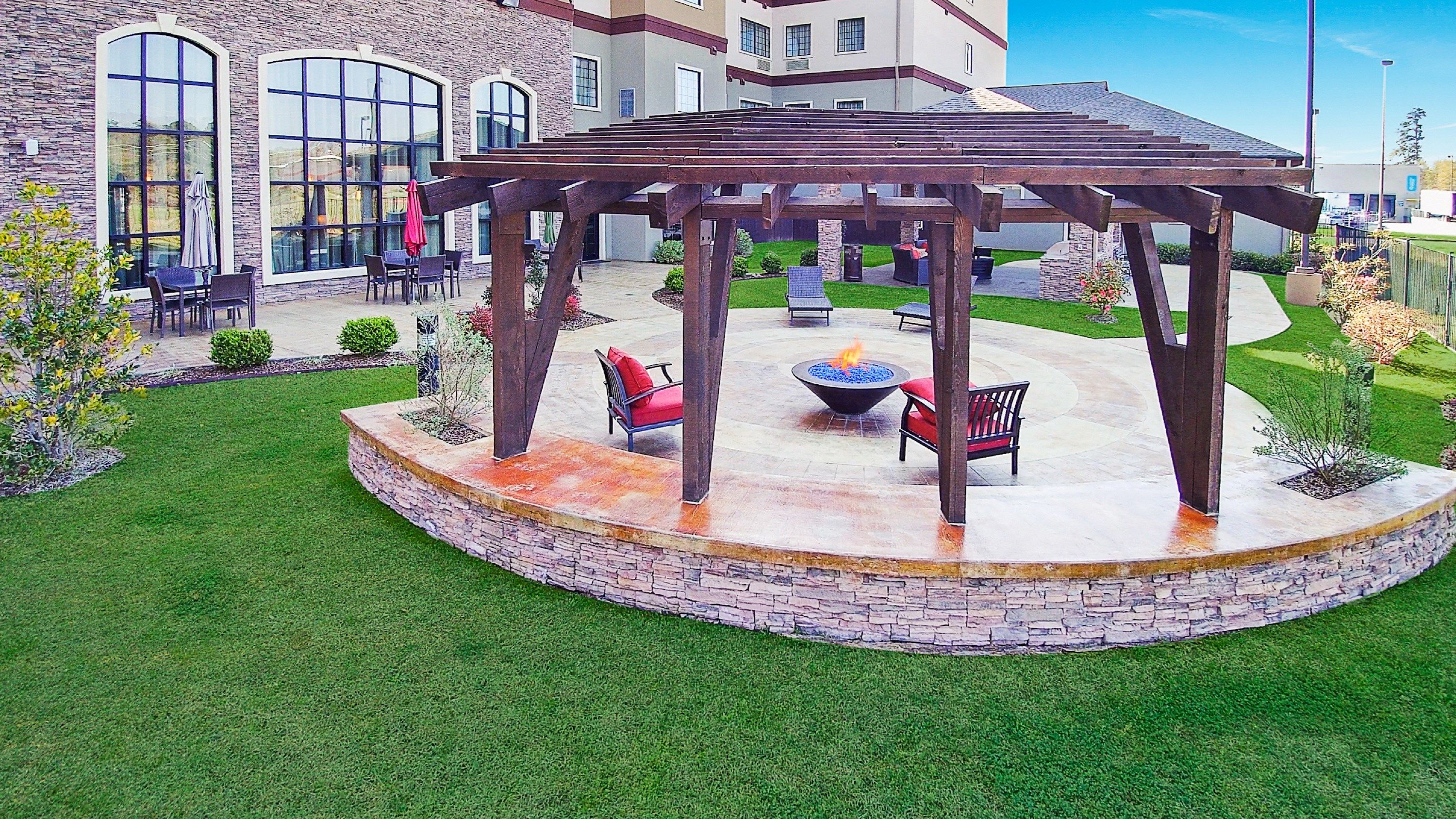 image Gather around the fire pit beneath the stylish pergola, ideal for cozy evenings and great conversation.