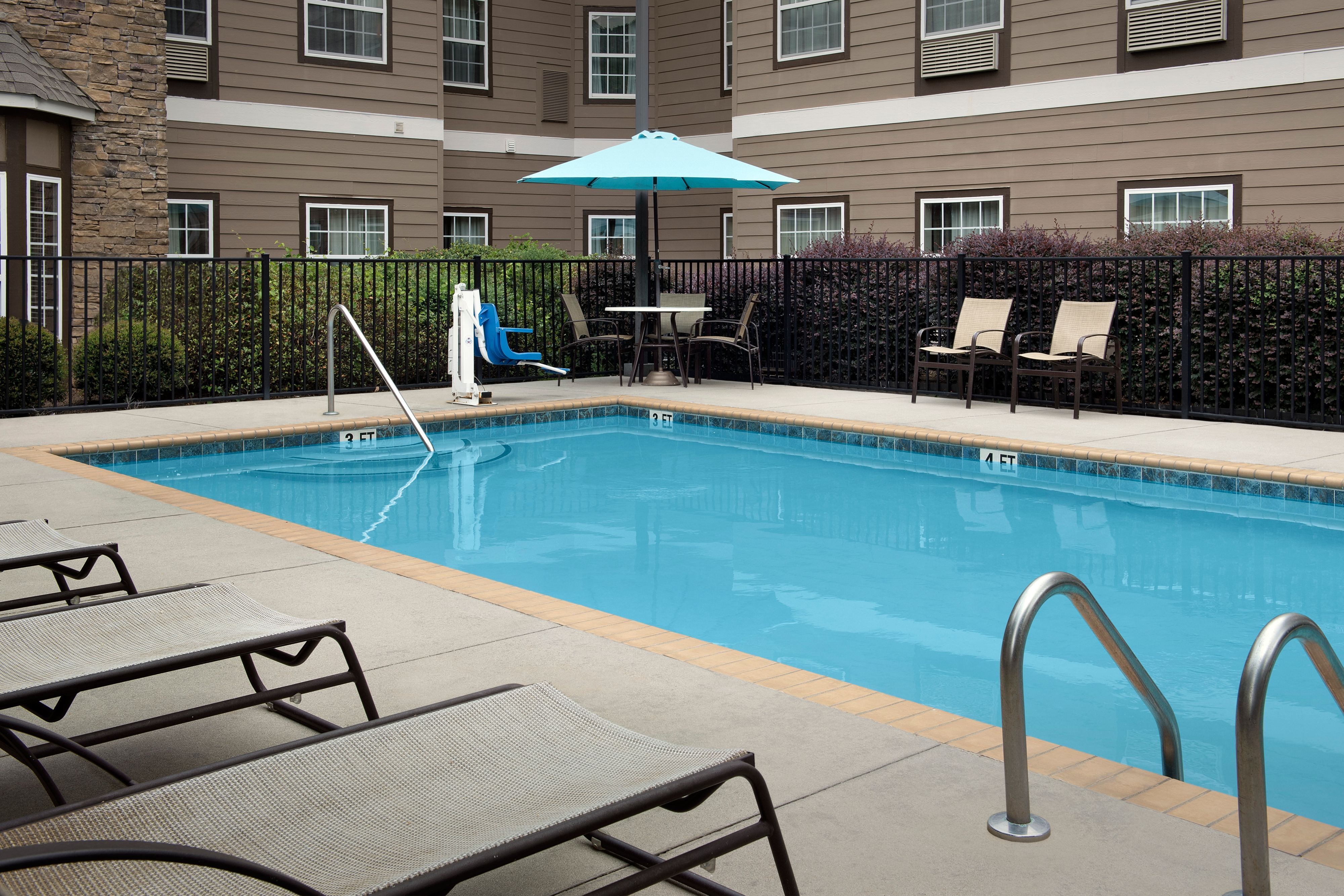 image Sparkling outdoor pool surrounded by comfortable lounge seating.