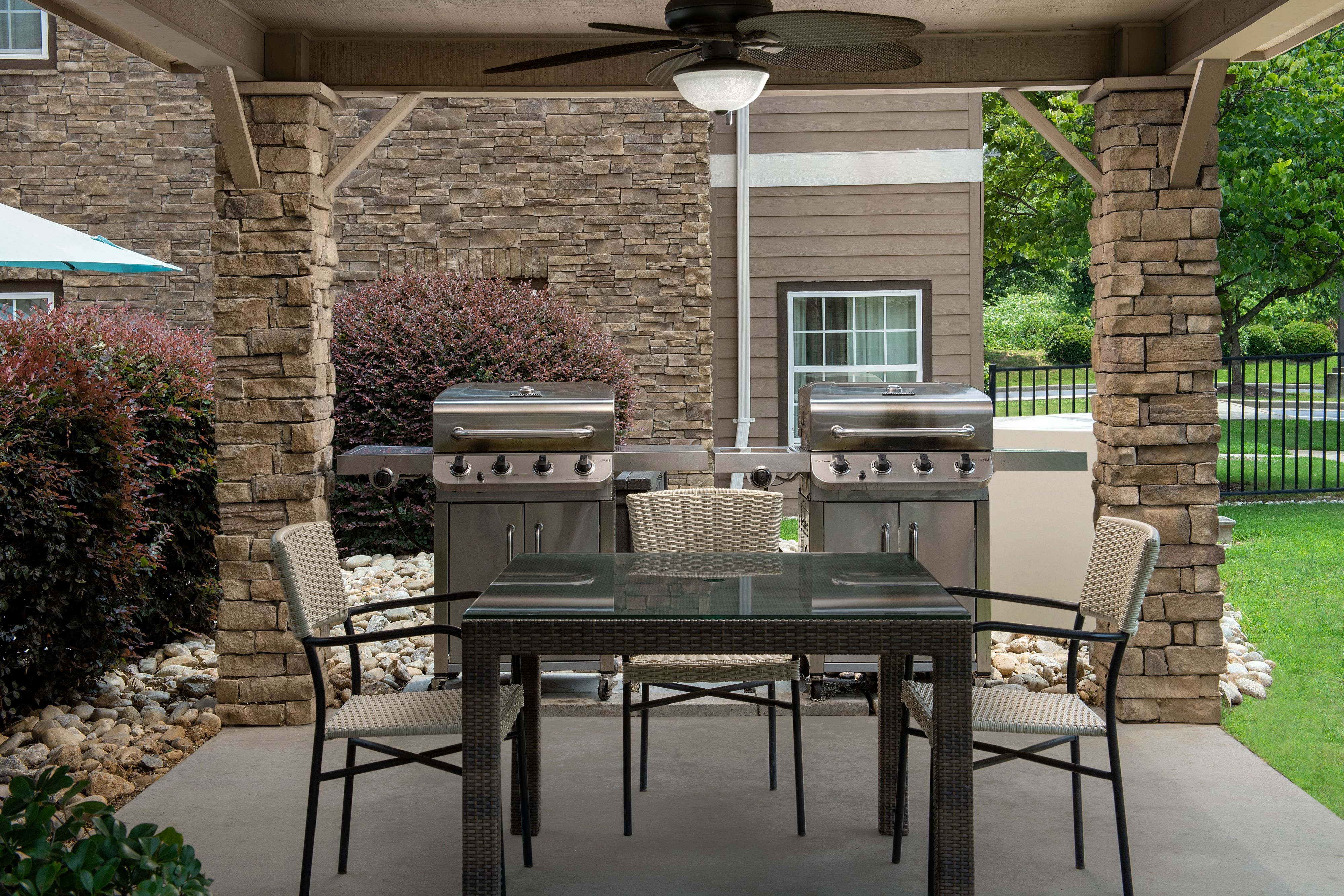 image Outdoor patio area with gas grills and dining table.