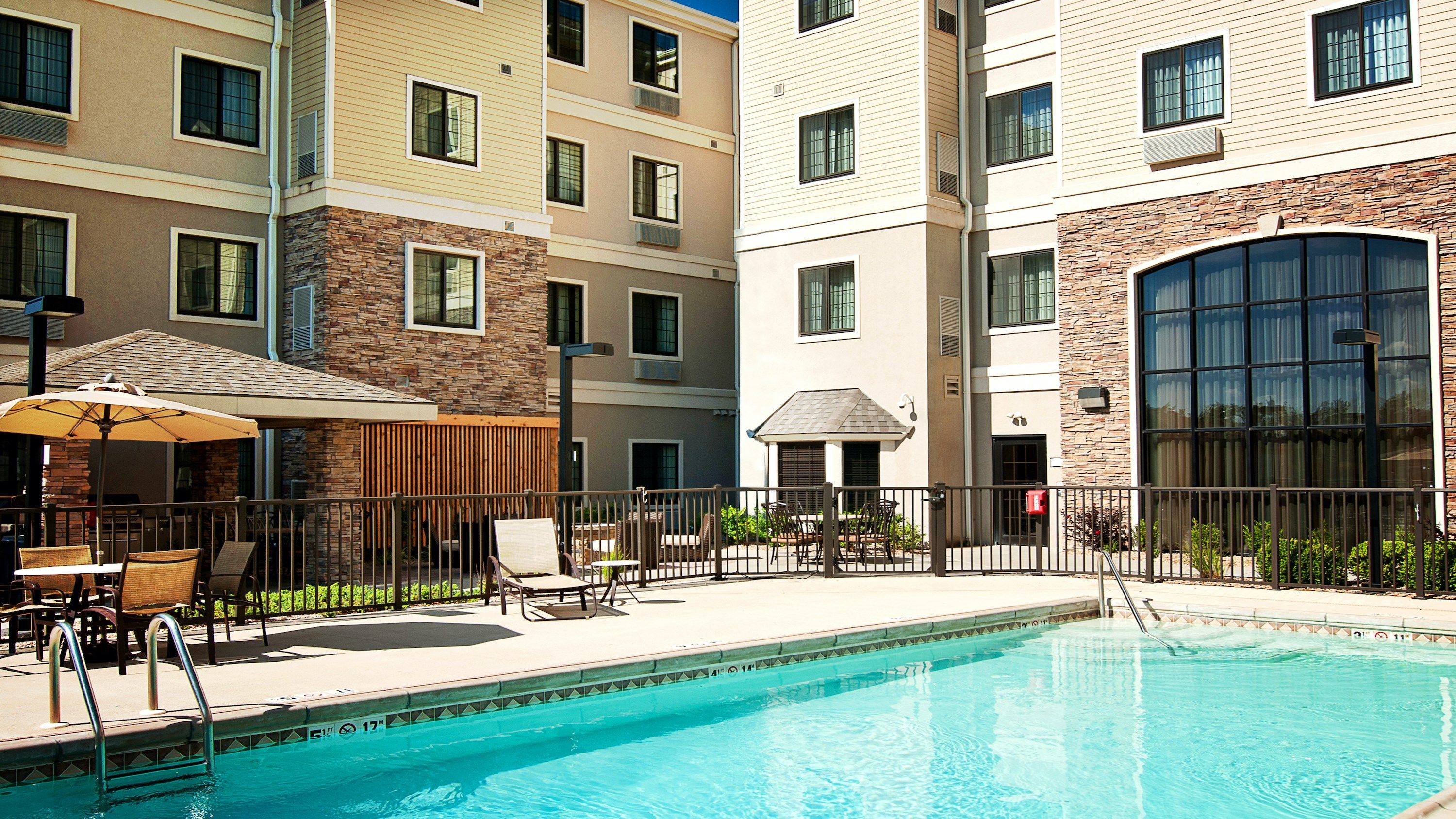 image Poolside seating under umbrellas during the outdoor pool season, June through August