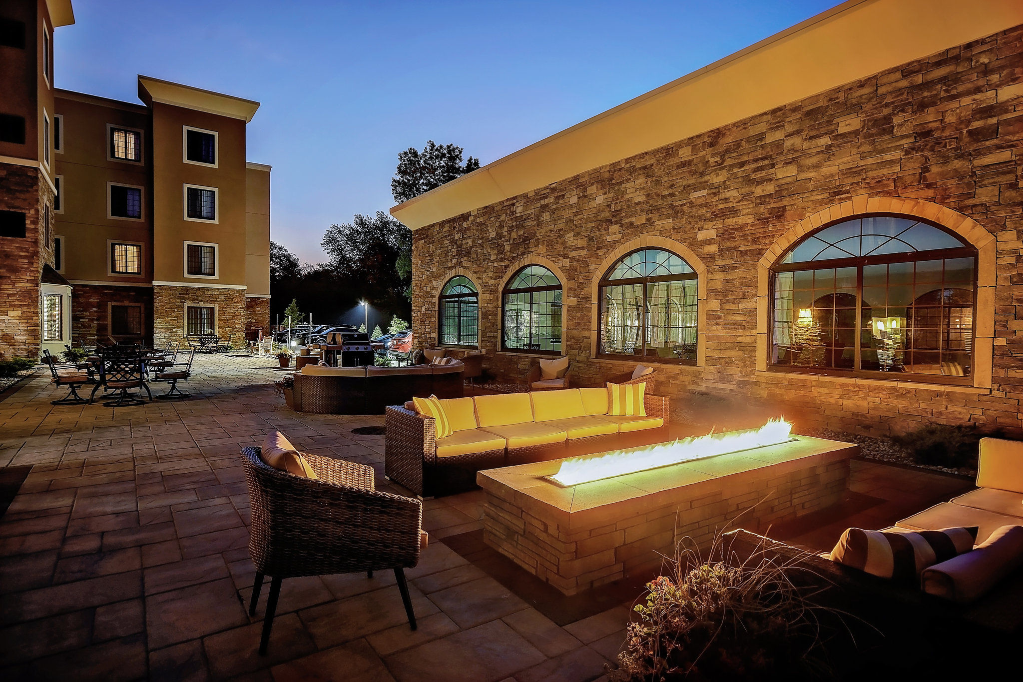 image Relax by the outdoor fire feature in a spacious courtyard setting.