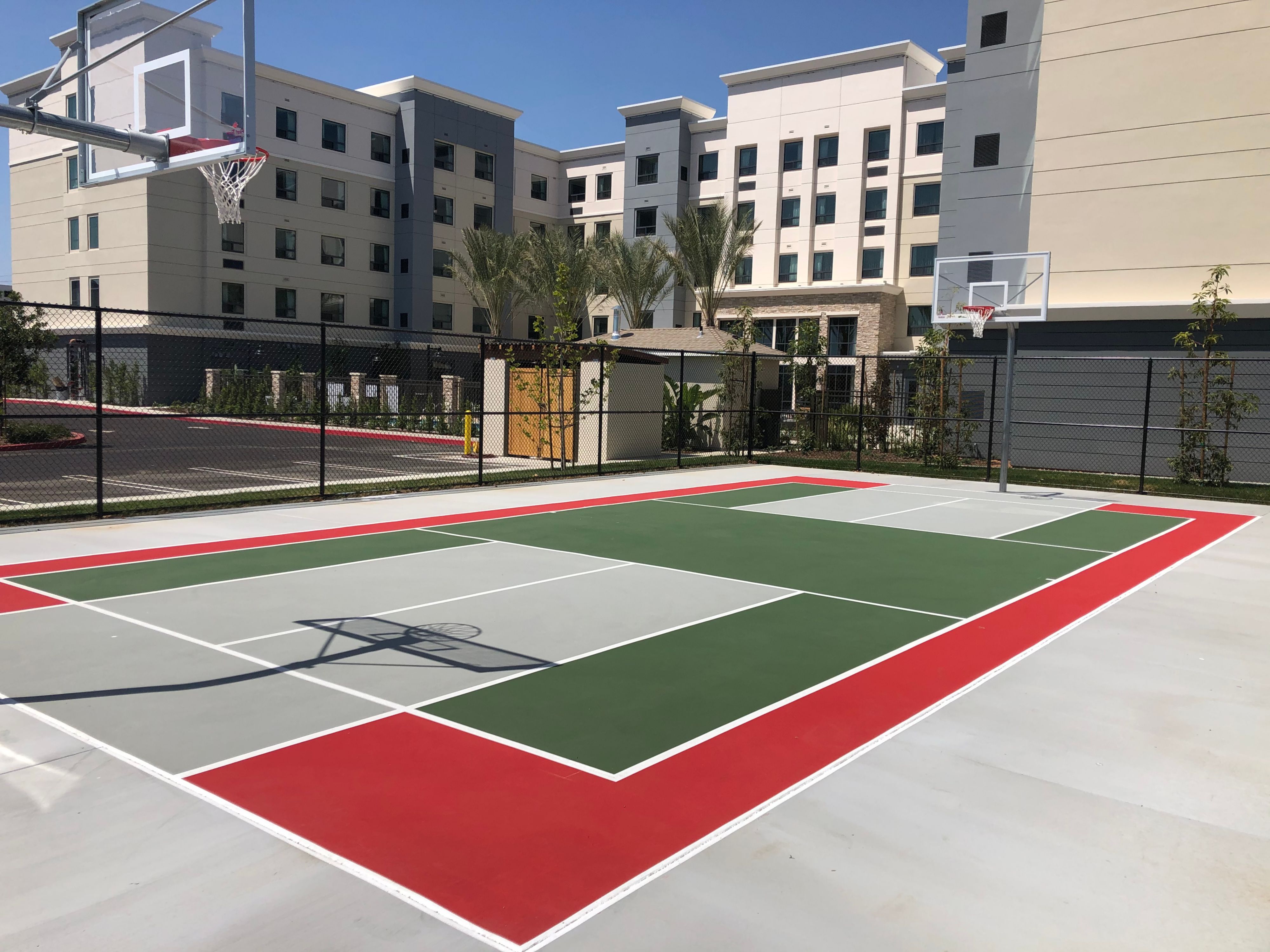 image Colorful outdoor basketball court surrounded by greenery.