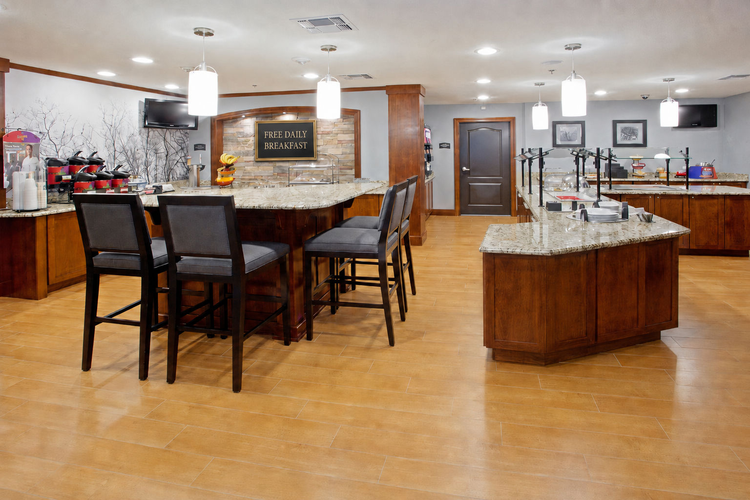image Expansive complimentary breakfast counter with multiple food stations and bar seating.