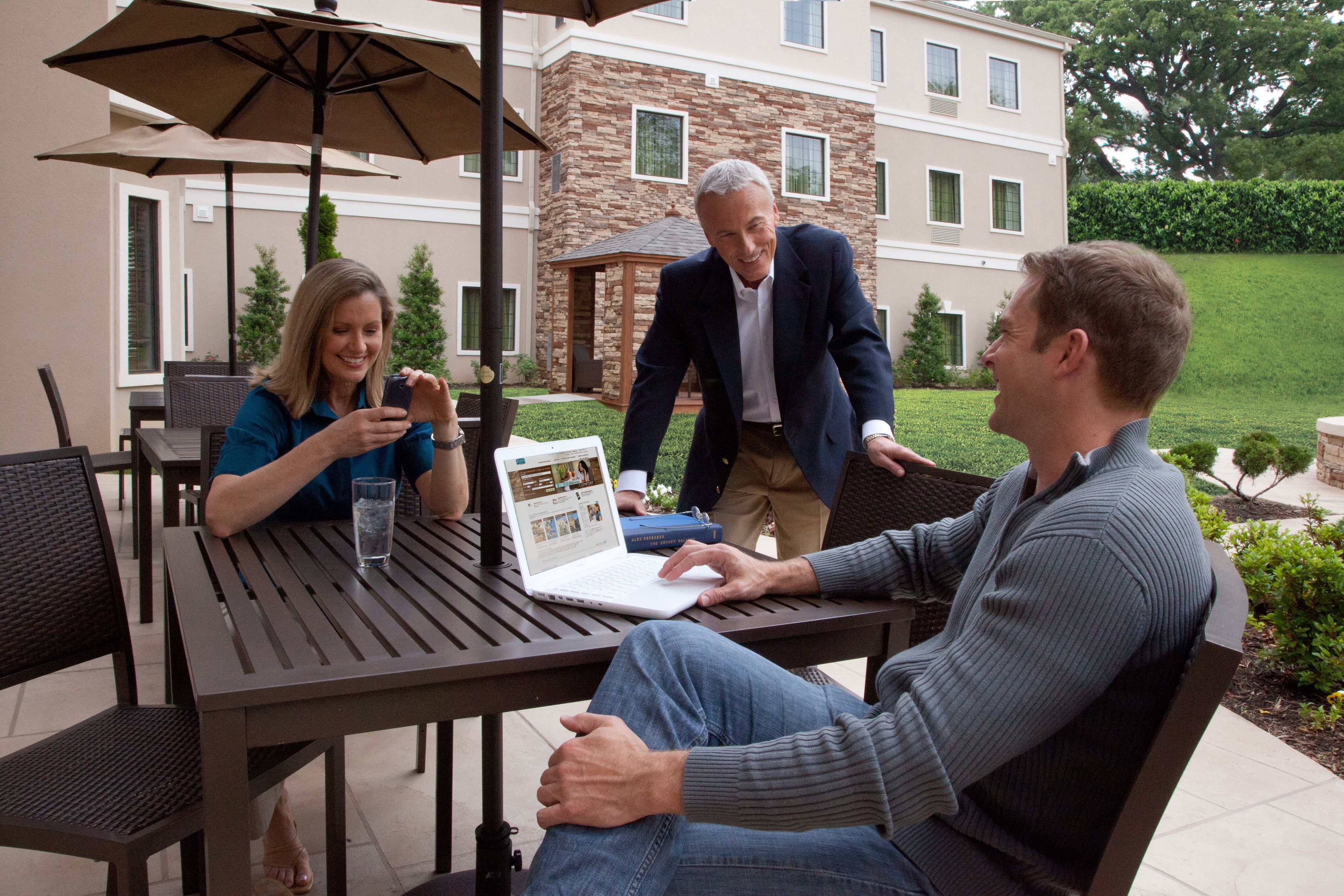 image Outdoor patio lounge with comfortable seating amid lush landscaping.