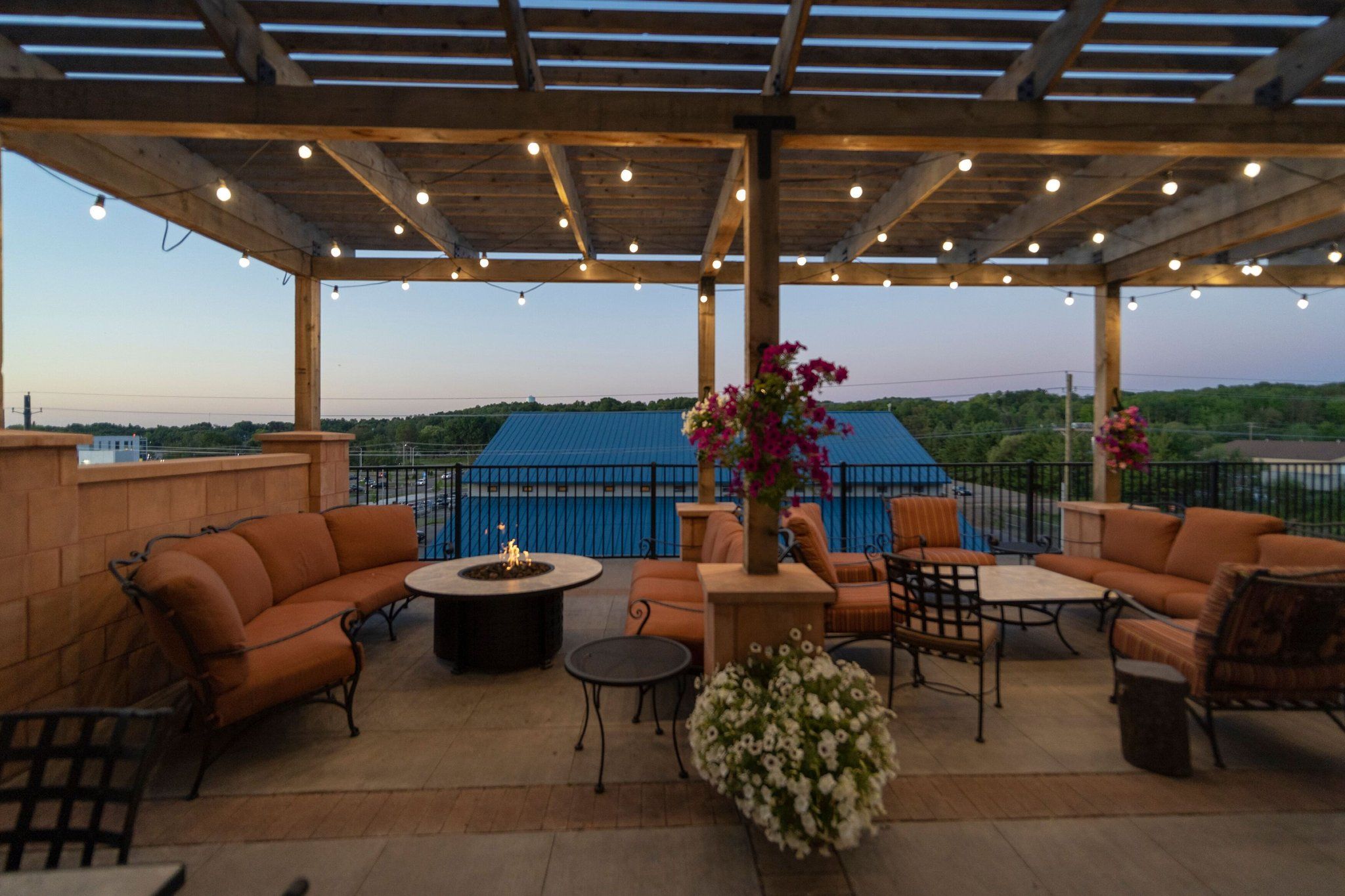 image Evening outdoor lounge with fire pit seating and decorative lighting.