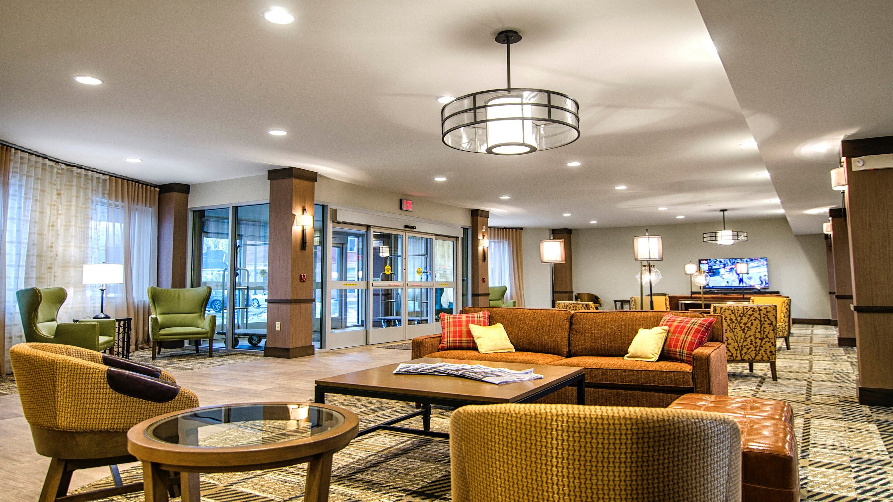 image Bright common area with large windows and comfortable lounge chairs.