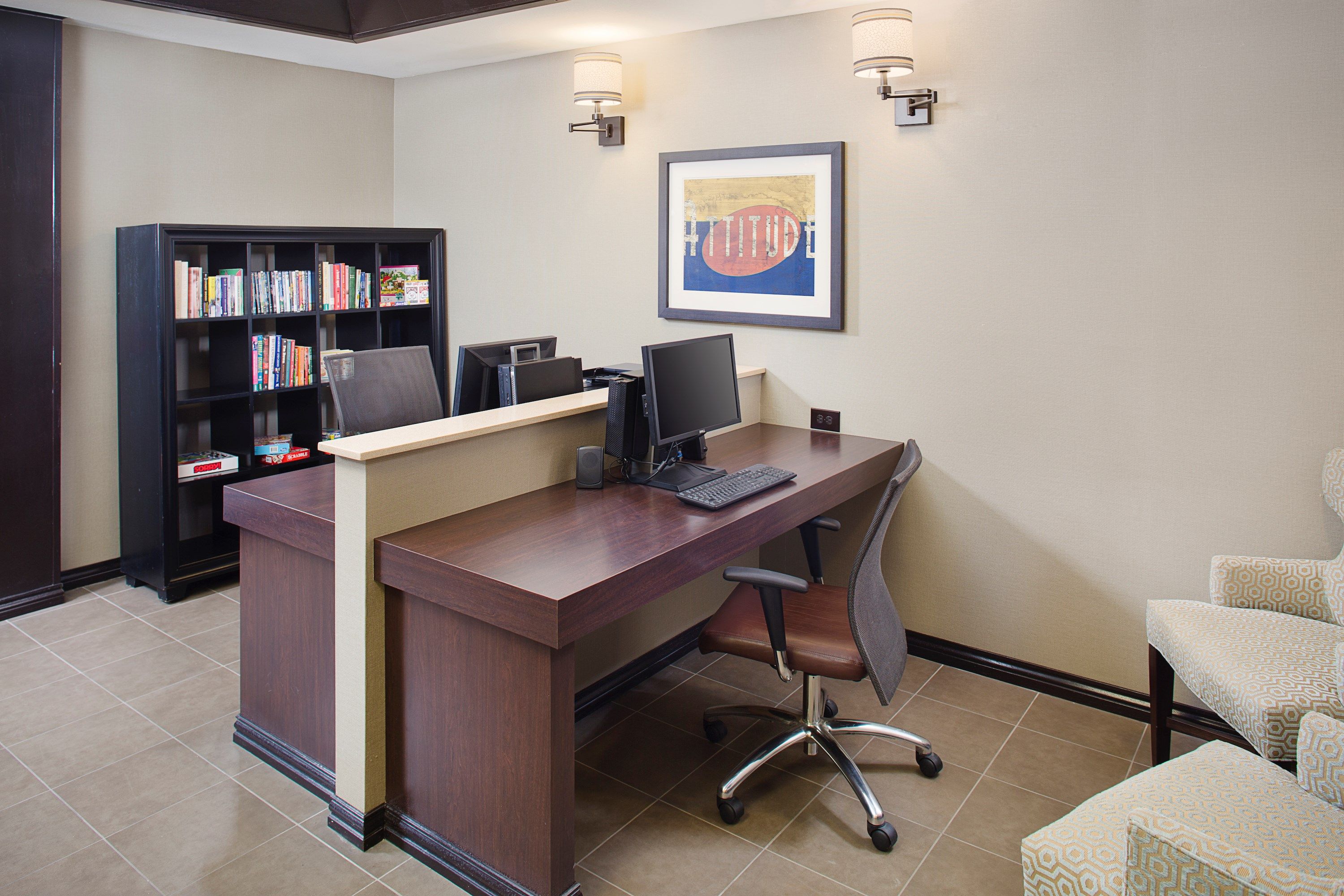 image Business center with computer workstation, bookshelf, and seating area.