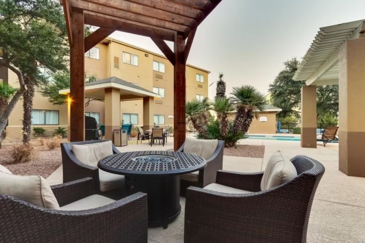 image Outdoor courtyard seating area with wicker chairs and desert landscaping.
