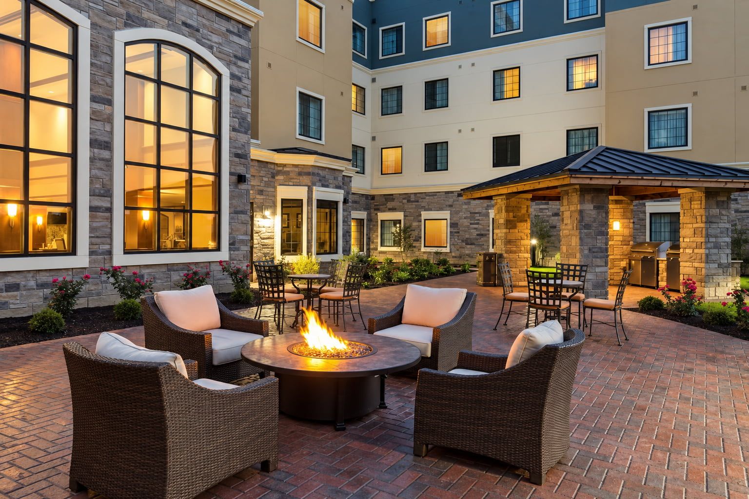 image Evening courtyard with fire pit and outdoor lounge seating.