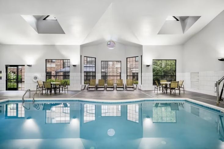 image Indoor heated pool open daily from 8 AM — lounge chairs line the deck for relaxing after a swim