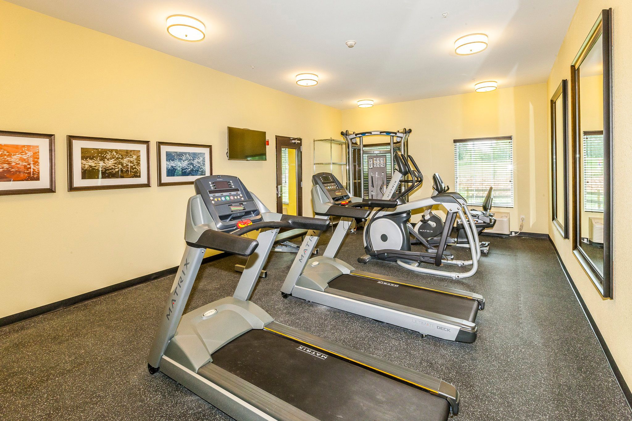 image 24-hour fitness center with treadmills, elliptical, and recumbent cycle — no need to break your routine