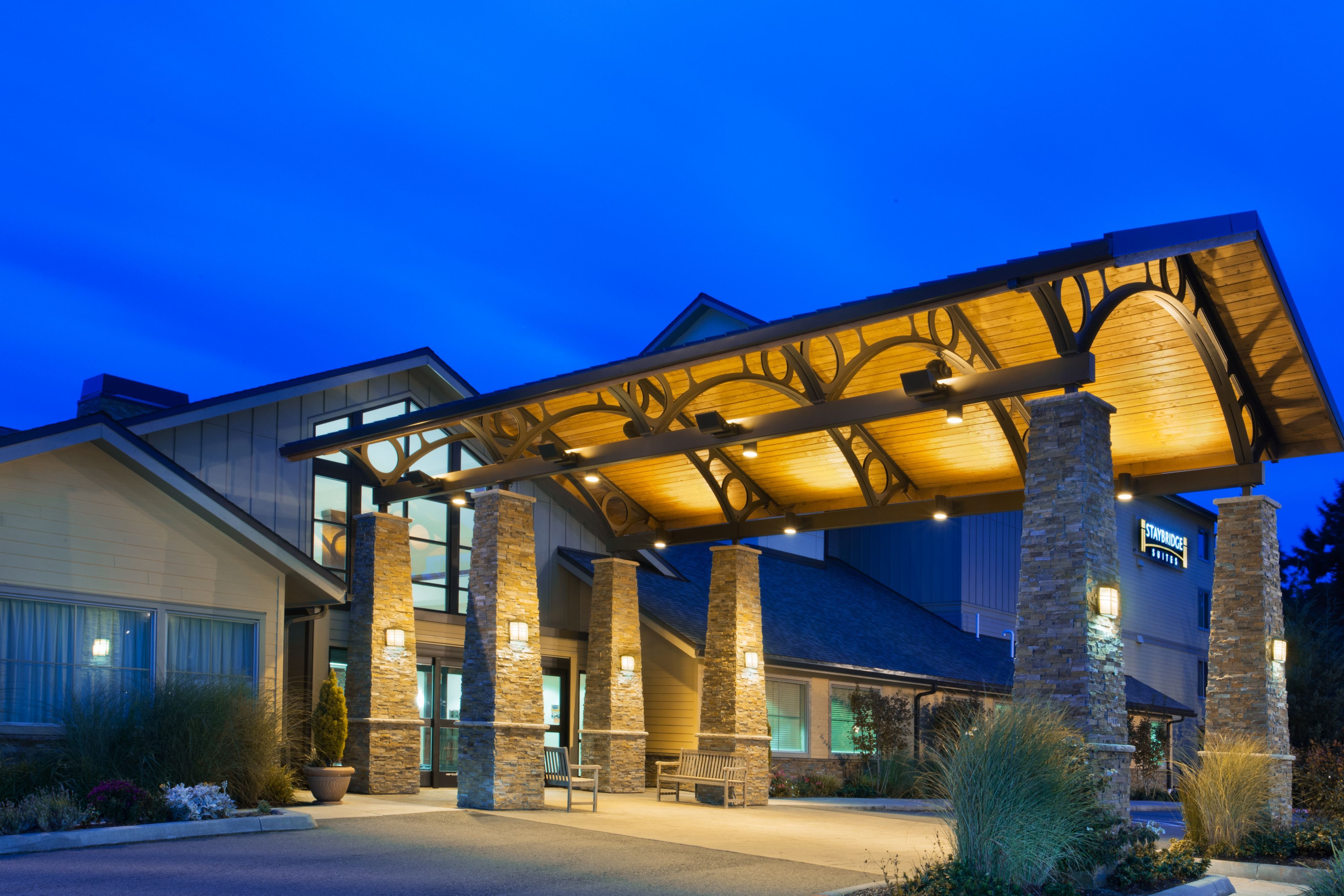 image A wood canopy and stone pillars mark the entrance, lit for evening arrivals