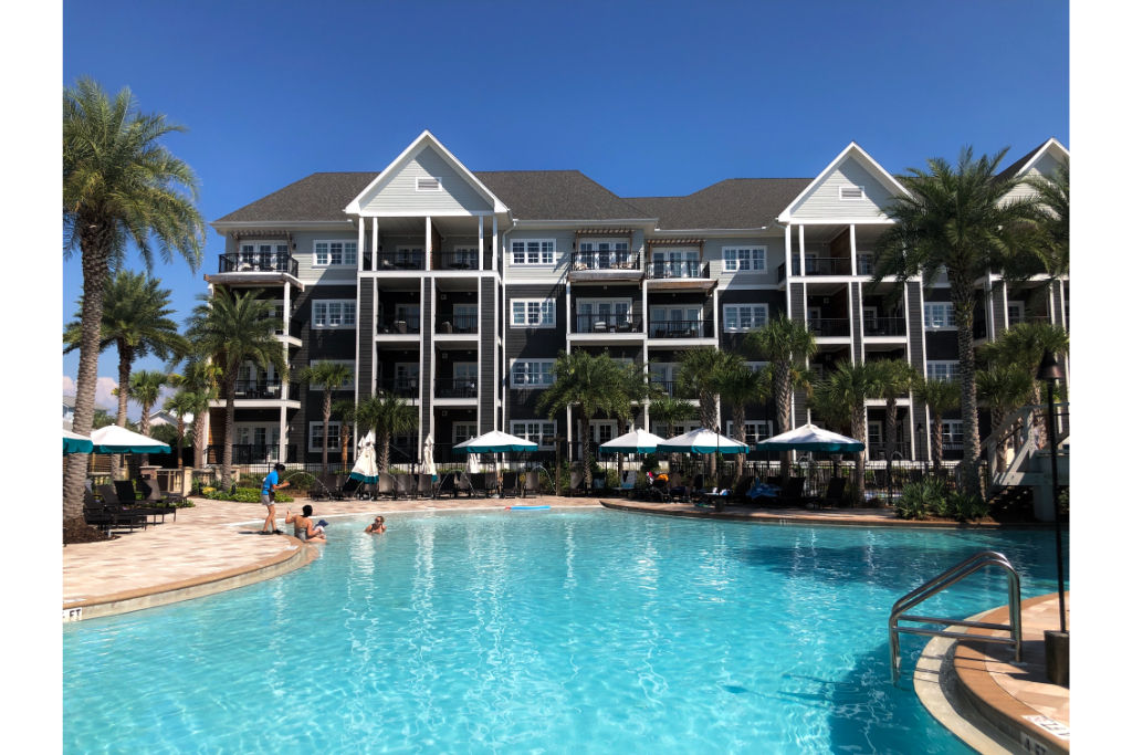 image A spacious resort pool flanked by palm trees, offering a refreshing escape.