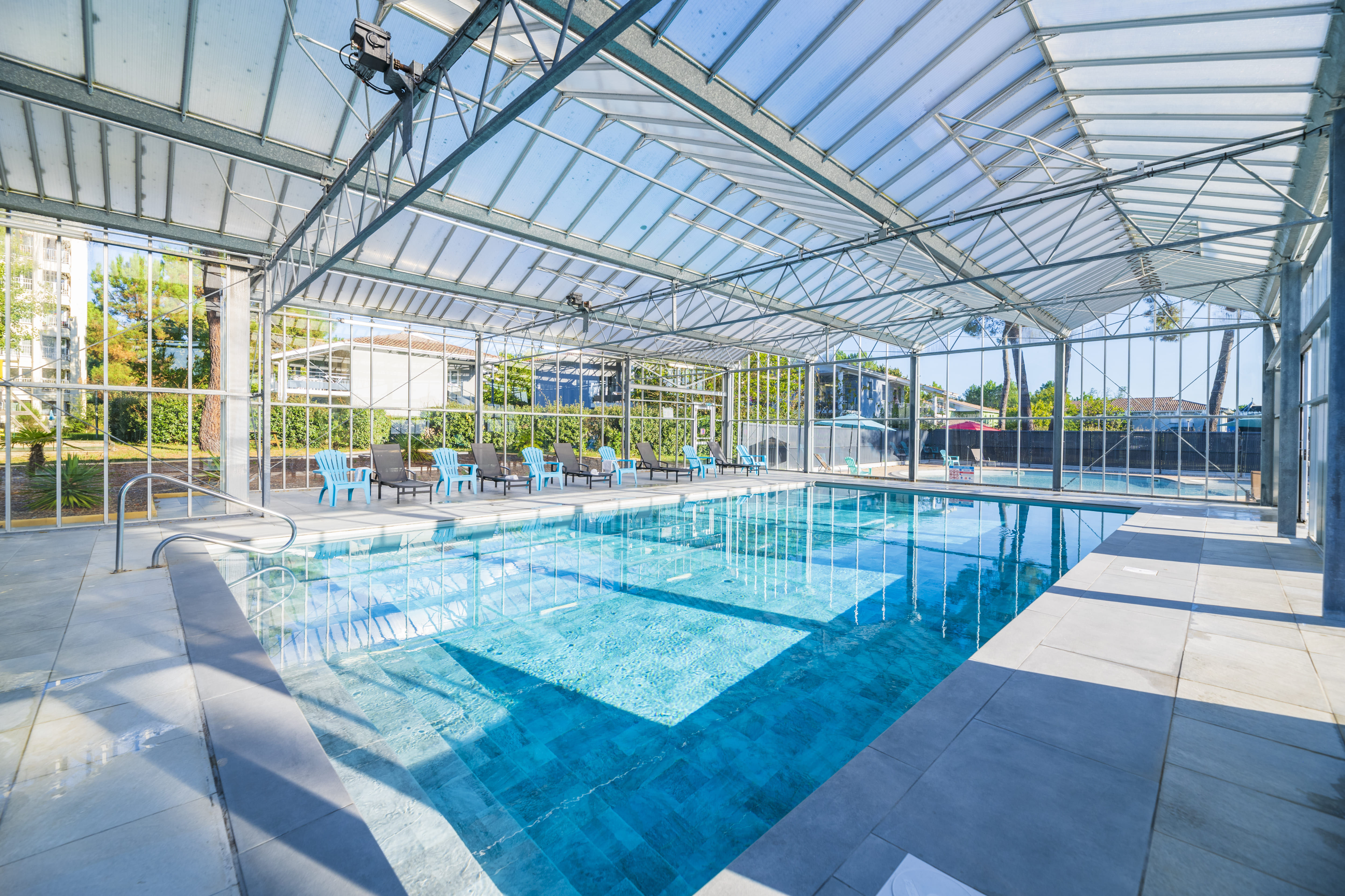 image Slip into the indoor pool beneath the glass-paneled roof, with loungers lined up along the tiled deck.