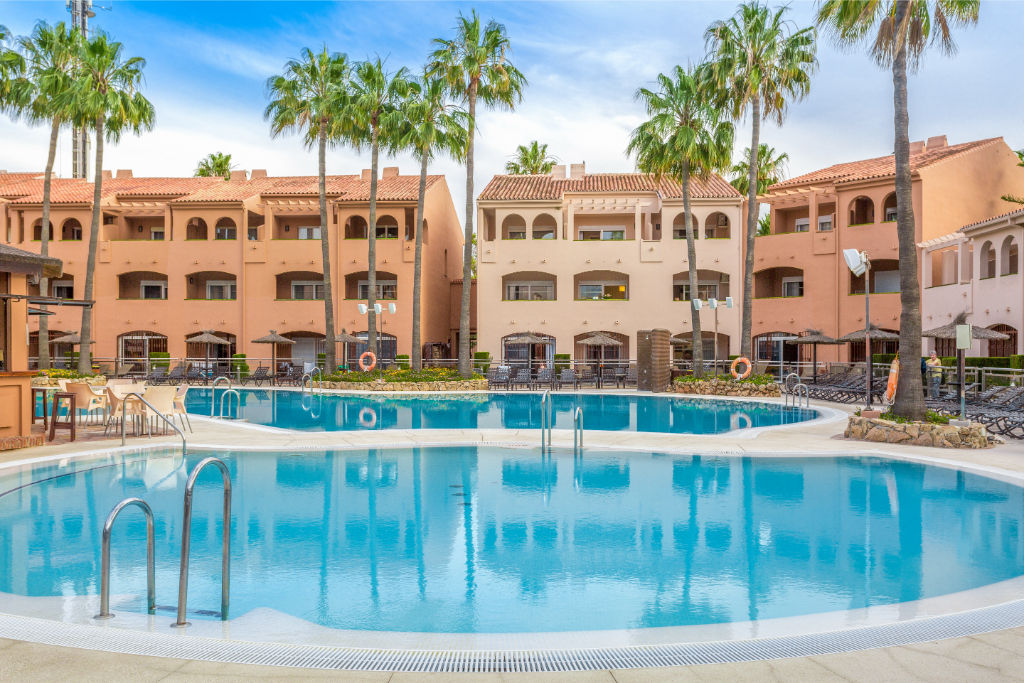 image Lush resort-style pool surrounded by palm trees for an oasis-like escape.