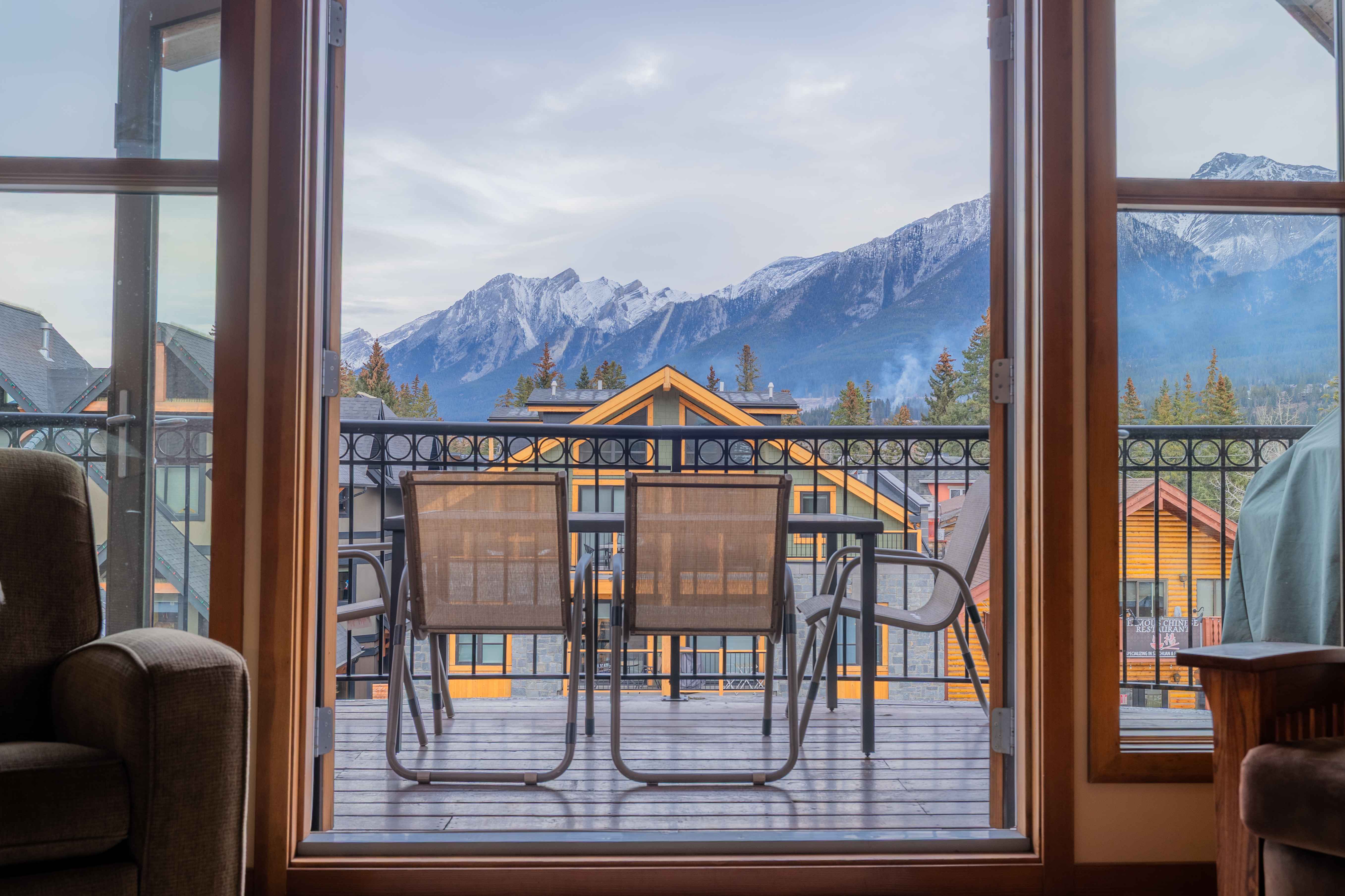 image Balcony dining space framed by mountain views and neighboring lodge-style buildings.