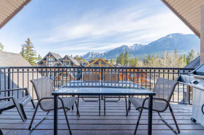 Outdoor balcony with a glass table and mountain view