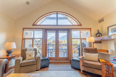 Bright living area with seating and mountain view through windows