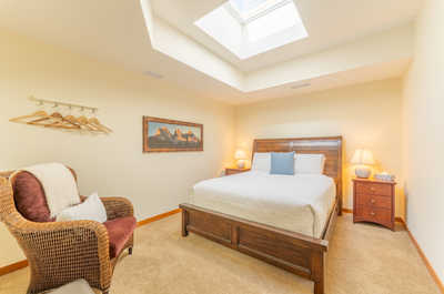 Serene bedroom with tray ceiling, bedside lamps, and crisp white linens.