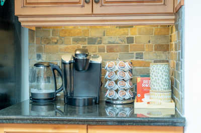 Coffee maker, kettle, and storage on a countertop