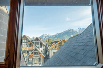 View of nearby buildings and mountains from a window