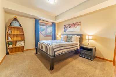 Charming bedroom with striped bedding, accent shelving, and soft neutral palette.