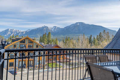 Balcony view overlooking mountains and a nearby building