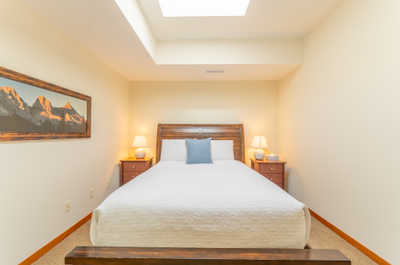 Minimalist bedroom with a skylight, wooden furniture, and lamps