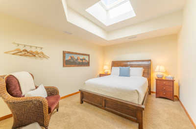 Bedroom with a skylight, seating area, and decor on walls