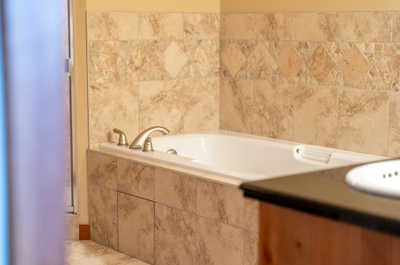 A closer look at the bathtub in a tiled bathroom with neutral colors