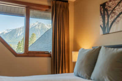 Bedroom corner with mountain view, soft lighting, and curtains