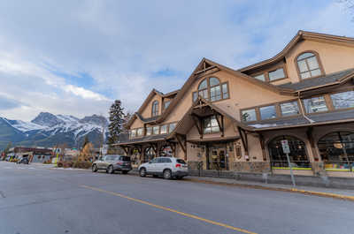 Commercial building with parking and mountain backdrop