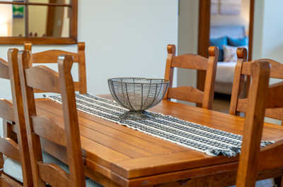Wooden dining table with a wire bowl and table runner