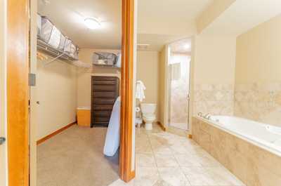 Spacious ensuite bathroom with deep soaking tub, tiled surround, and separate shower area.