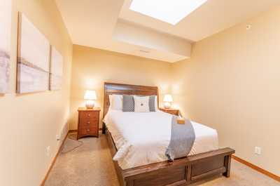 Bright and airy bedroom with vaulted ceiling detail and cozy bedside lighting.