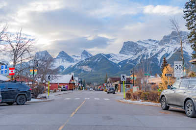 Street view with mountains, shops, and cars along the road