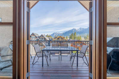 Outdoor balcony with table and chairs, mountain backdrop