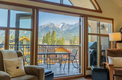 View of mountains and trees through large glass windows