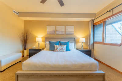 Bedroom with bed, lamp, and large window